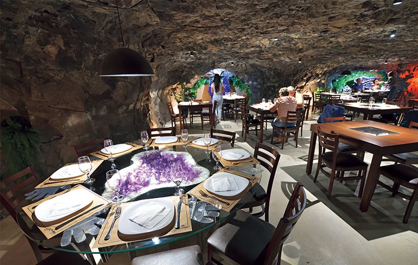 テーブルの中央にアメシストのジオードが煌めくレストランは元は鉱山。連日観光客で賑わう。