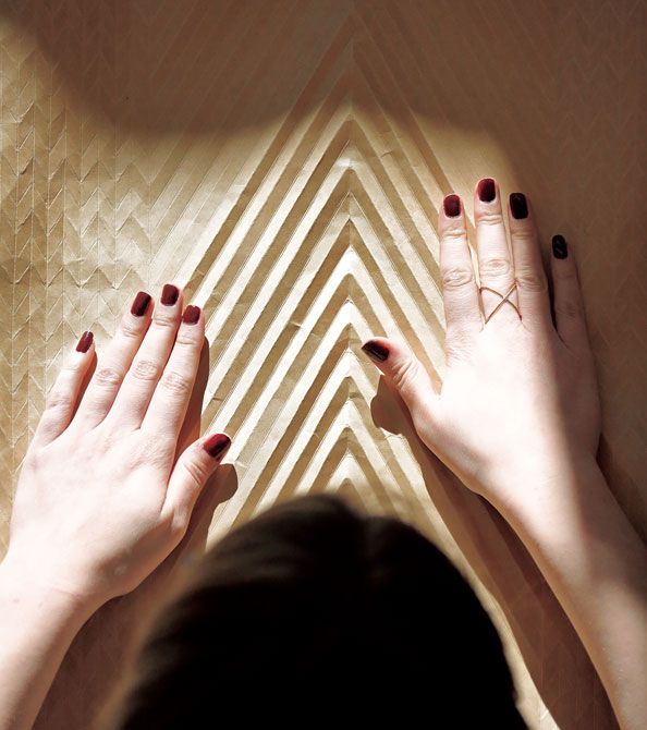 デザインされたモチーフをクラフト紙に描き出し、その描かれた図案のとおりカートン紙に折り目がつけられプリーツの原型が完成。それらはすべて職人の手作業により行われます。©le19M-Anne Combaz