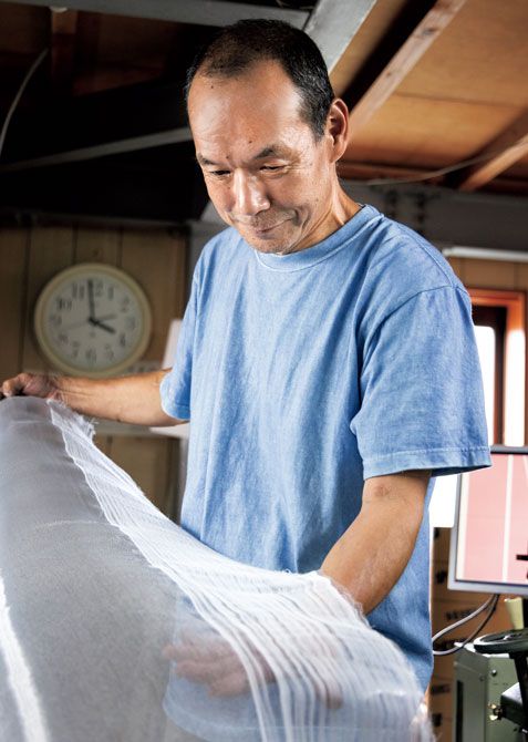 織り具合をチェックする豊島さん。金属織物は一日で10メートルほどのペースで織り上げるそう。