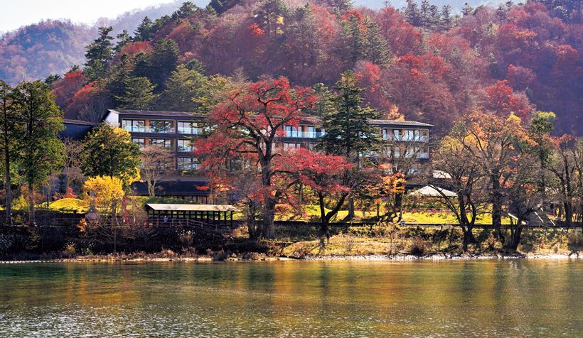 遊覧船から湖越しに見る「ザ・リッツ・カールトン日光」。周囲の自然にしっとりと溶け込む風情。施設は、既存の樹木をできるだけ残すようにして建てられた。