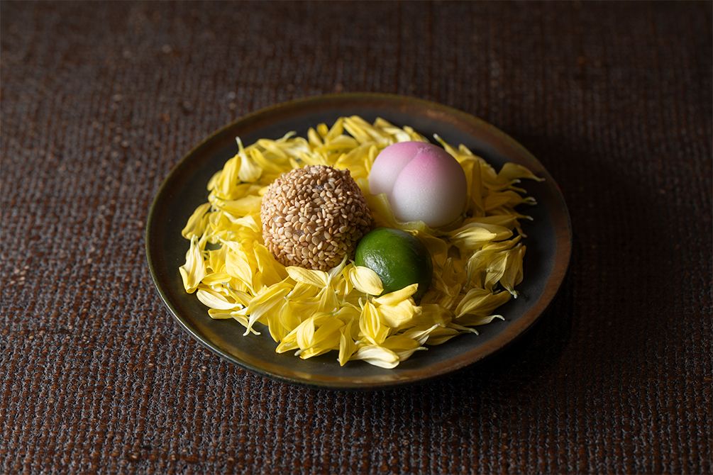 「三段おせち」の参の重の甘味だけを取り出して菊の花びらの上に。ひと手間で、可愛らしいデザート皿が完成。