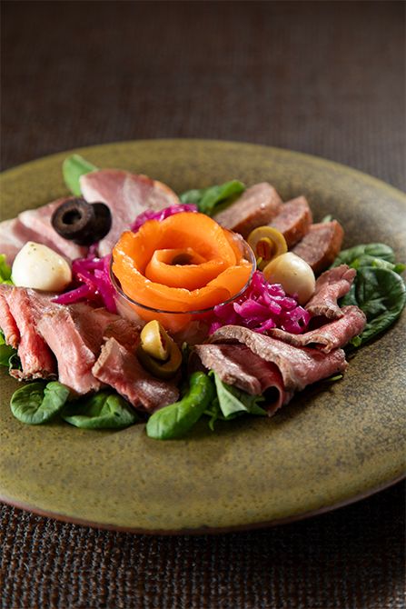 「三段おせち」の弐の重に入ったローストビーフは薄切りにして食卓に出すとより華やかに。同じ重に入っているスモークサーモン、オリーブ、モッツアレラチーズなどを一緒に合わせる。