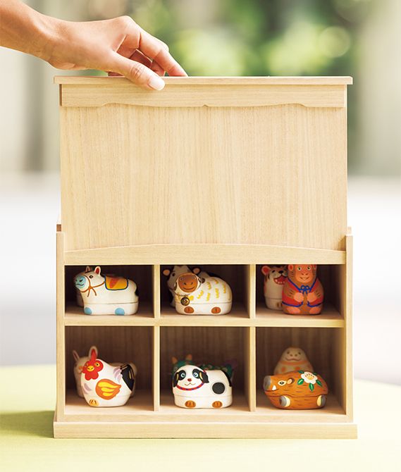 上下2段の6スペースには2個ずつ干支の動物が収まり、前面の板を上げ下げして開閉する。