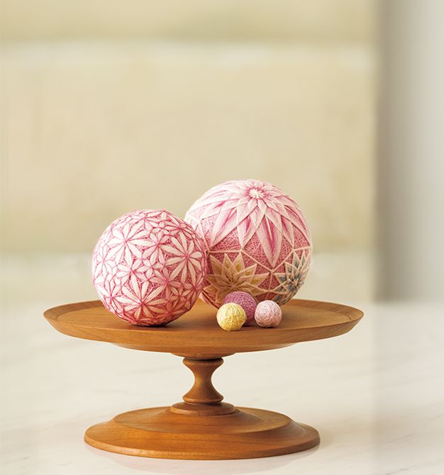 ピンク系を中心に暖色でまとめ、ブルーがアクセントの配色。飾り台は上下を逆にしても使用でき、菓子皿やアクセサリー台にも転用できる。