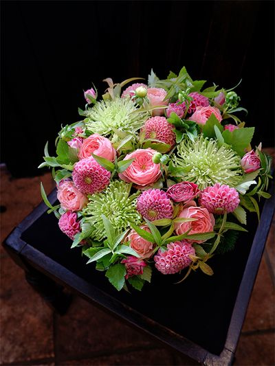 秋〜晩秋にかけて、花色がぐっと深くなるピンクのダリアとバラの共演アレンジです。ダリアは‘サックルローズピンク’、バラは‘ハーパー’と‘チアフル’。マム‘アナスタシア’の淡い緑色は、ピンクとちょうど反対色の関係で、お互いを引き立て合う色合わせです。スマートな葉は初夏に水色の花を咲かせるチョウジソウ。チョウジソウの黄葉が加わると、アレンジ全体が秋深い印象になります。きれいに黄葉することからチョウジソウはガーデンでも人気があるそうです。