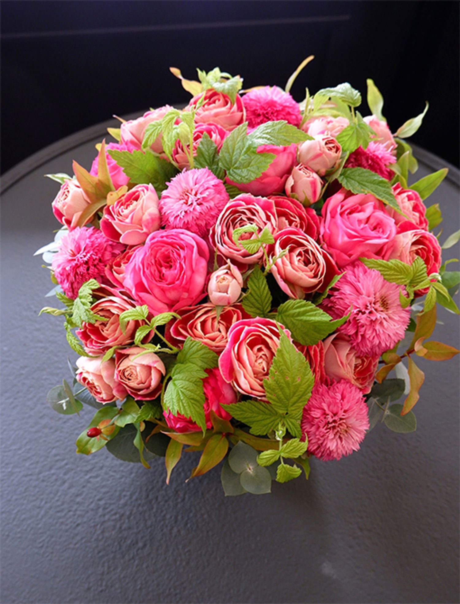 還暦を迎えた友人にお祝いのアレンジを。バラの‘ローズシノ’と‘チアフル’に、エキナセア‘ピンクボールビュー’を加えて束ね、原種系紅葉ヒペリカムとフランボワーズの葉をあしらいました。エキナセアは夏の花ですが、この時期まで出回り、花サイズもひとまわり大きくなっています。紅葉した葉とフレッシュグリーンの葉を対比させると、贈り花の表情が豊かになります。