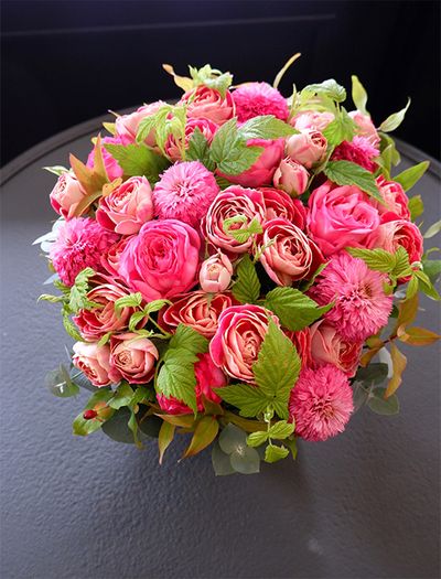 還暦を迎えた友人にお祝いのアレンジを。バラの‘ローズシノ’と‘チアフル’に、エキナセア‘ピンクボールビュー’を加えて束ね、原種系紅葉ヒペリカムとフランボワーズの葉をあしらいました。エキナセアは夏の花ですが、この時期まで出回り、花サイズもひとまわり大きくなっています。紅葉した葉とフレッシュグリーンの葉を対比させると、贈り花の表情が豊かになります。