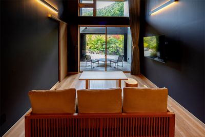 定員2名の「モダンツインルーム」。天井が高く開放的で、64平方メートルの広さがある。地元の庭師が造ったという庭園向きに置かれたソファに座れば、日本らしい四季の草花を望む。テラスの脇には露天風呂も。