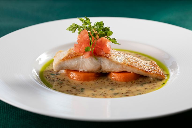 サツキマスのポワレ。白ワインと粒マスタードなどを使ったソースでいただく。「やさしい味わいの魚には、樽熟成され香り高く、コクのある味わいに仕上げられた白ワイン『光 甲州』（4730円）がおすすめです」と広田さん。