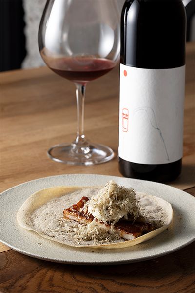 創業時から変わらない人気を誇るスペシャリテ「うなぎのガレット」には、「芒（NOGI）」2020の赤を合わせて。そば粉のガレットに、うなぎ、奈良漬け、マスカルポーネチーズ、トリュフが重なる。「マスカット・ベーリーAの持つ甘みが、うなぎのうま味を引き出します。ワインは、食事があってこそよりおいしさが引き立つと思います」と平山さん。