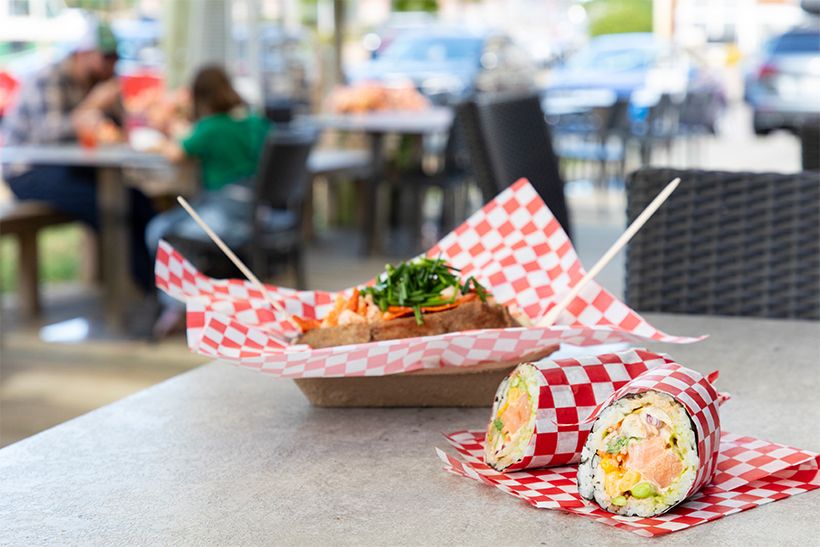 左奥・「Dal’s Potato Bar」のロブスター・ベイクド・ポテト（29.90Ｃ＄）。手前・「Hojo’s Sushi Burrito」のすしの食材をブリトーのように巻いた「寿司ブリトー」 （12Ｃ＄～）も人気。