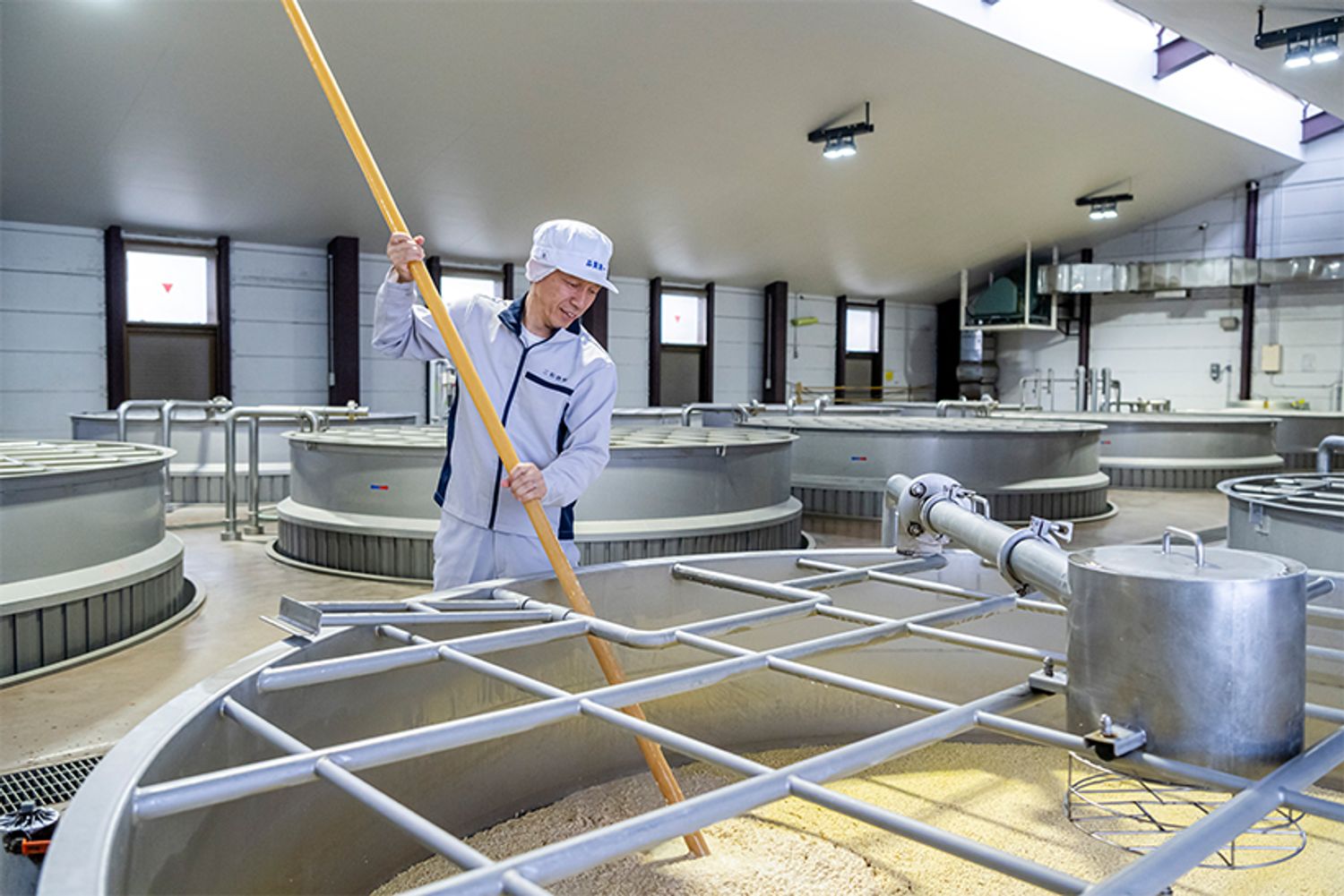 熟練の蔵人による一次仕込みの櫂（かい）入れ作業。大麦麹に水と酵母を加えて撹拌し、5日ほどかけて発酵させる。