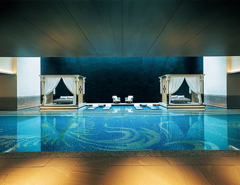 自然光が降り注ぐエキゾチ ックな温水プールは地下2階に。サウナや温泉も併設する。