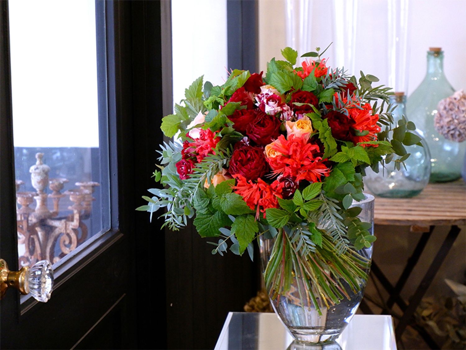 赤バラの‘キララ’と赤白のバラ‘フリューレット’にアプリコット色のバラ‘ビーハイブ’を合わせたブーケです。朱赤のダイヤモンドリリーを加えると、赤の深さがよりアピールされます。フランボワーズ、アカシア‘ブルーブッシュ’、ユーカリ‘アップル’など、たっぷりのリーフをあしらってナチュラルに仕上げました。