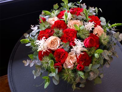 くしゅっとした花形が魅力の赤バラ‘レッドワインローズ’と白さが際立つクリスパリリーの対比が印象的なアレンジ。対比が強くなりすぎないように、淡いベージュのバラ‘ウエストミンスターアビー’を加えています。ほかにニゲラ‘グリーンマジック’、ビーンズリーフ（スナップエンドウの新葉）などを使用。