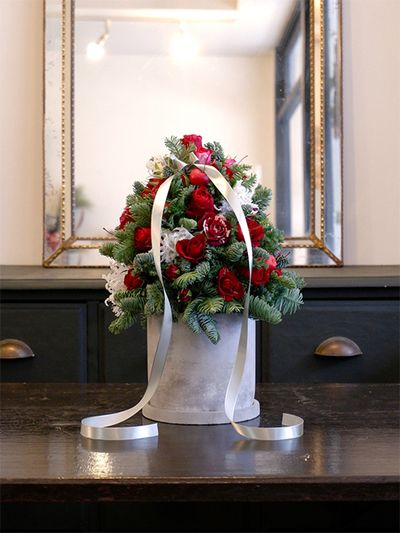 赤バラの‘ブリランテ’と‘ルビーブリリア’、‘フリューレット’を使ってクリスマスツリーのアレンジを制作しました。フローラルフォームを三角錐に削って鉢に固定し、そこに花を挿していくとツリーの形になります。部屋に飾ればクリスマスの雰囲気が一気に盛り上がります。ほかに白いクリスパリリー、ヒメリンゴ、コニファー‘ブルーバード’を使用。