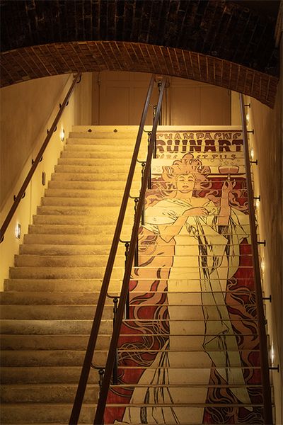 かつてポスターに使われたアルフォンス・ミュシャによる絵が、地下へのカーヴをつなぐ階段に描かれている。