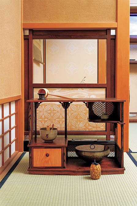 透かし入りの寄木棚は家元の古稀にちなんで7種の木を用いたもので、地板は七角形。2代井川信斎作。茶入の仕覆は流祖が西陣に特注して織らせた金襴、小堀裂。茶碗は遠州好みの「夢」の字茶碗。