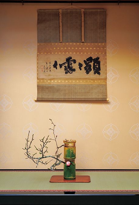 掛物「顕々露々」は若宗匠が修行した大徳寺龍光院の開祖江月和尚の筆。中廻しと風帯の裂は江月和尚の九条袈裟と同じ団龍金襴。花は曙椿と老木の白梅、若木の紅梅。道具組みは2025年の点初めのもの。