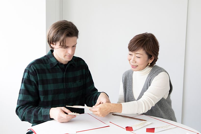 錦織ほまれ先生（右）に教わりながら、真剣に折形を学びます。