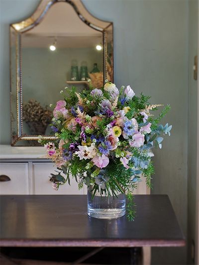 ‘ペッシュ’の淡いピンクに、ラナンキュラスやパンジー、アスチルベなど春のパステルカラーを合わせたブーケを誕生日の贈り花に。ニゲラ‘ミスジーキル’の水色が加わるとぐっと大人っぽくエレガントな印象になります。ラナンキュラスの‘リナレモン’と‘オルレアン’、パンジー‘カルメン’、アスチルベ‘アプリコット’などを使用。アスパラガス・スプレンゲリーなどのリーフをたっぷり加えてナチュラルな印象に仕上げました。