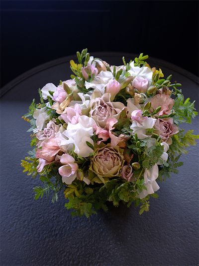 染めのスイートピー‘メロウ’とくすみ系の花色が魅力的なバラ‘ラピスヴェール’。アンテク感のある花色の2種を合わせると、落ち着いた雰囲気の上品な贈り花に。純白のスイートピー‘ロイヤルホワイト’を加えると、くすみ系の花色がより際だって見えます。ほかにフリージア‘エアリーシェルピンク’、銀葉アカシアを使用。いつもおしやれな友人の誕生日を祝うアレンジです。