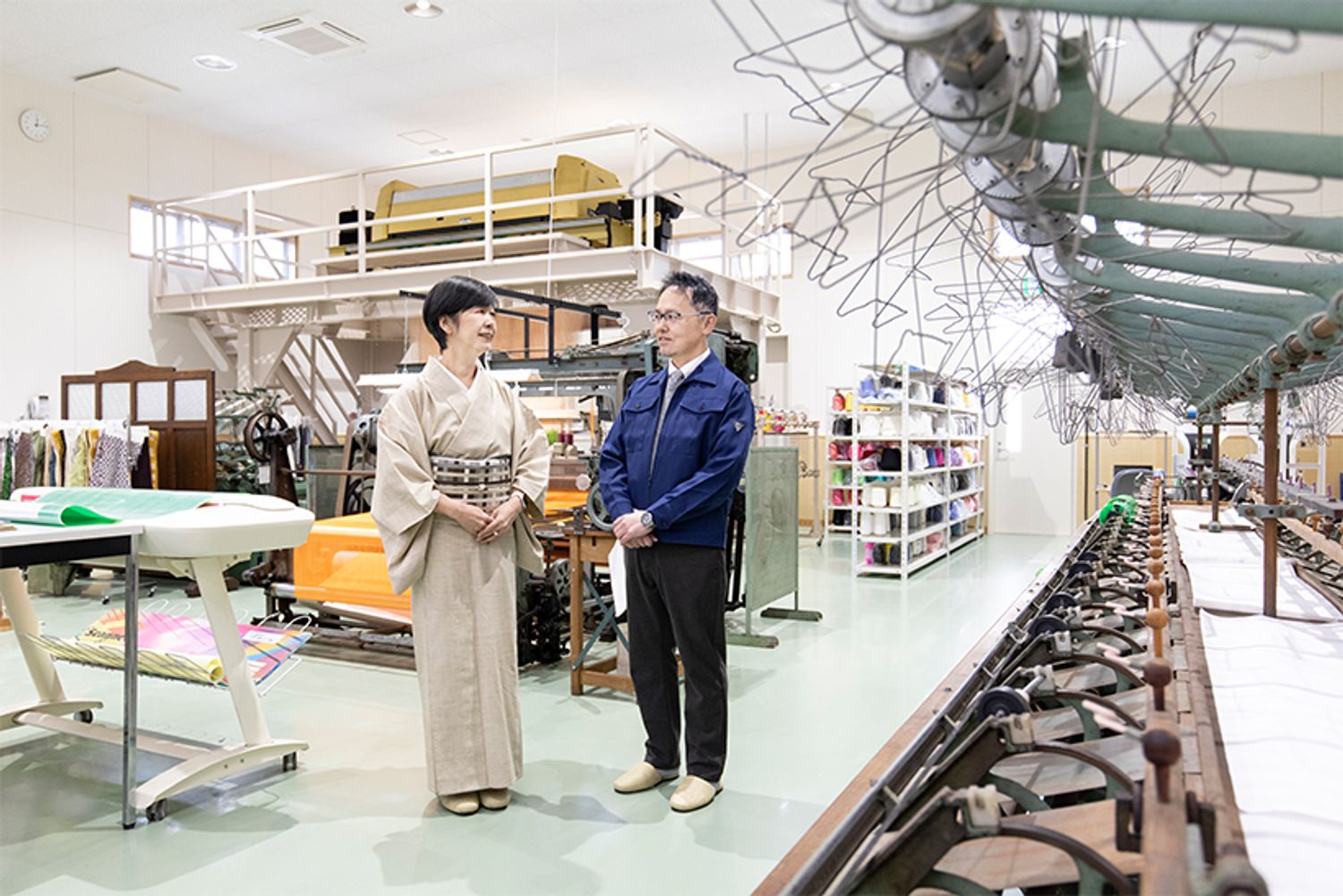 様々な織機が置かれた研究施設で語り合う五十嵐さん（右）と田中さん（左）。