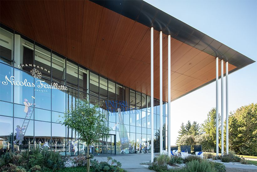 空と緑が映り込むガラスが印象的な、洗練されたモダン建築。エペルネ駅からの送迎プランも用意されている。