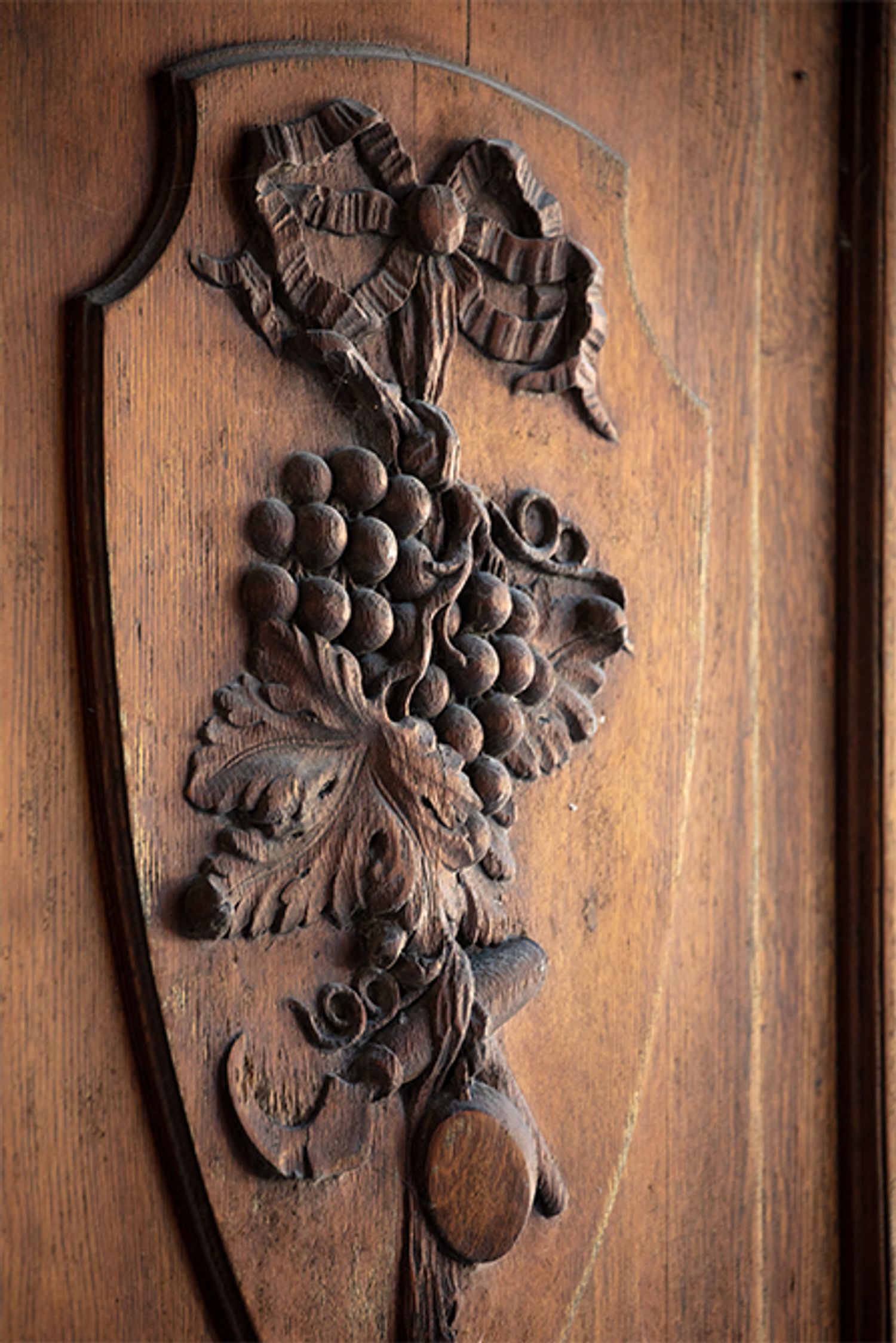 入口の木の扉に施されたぶどうの彫刻。