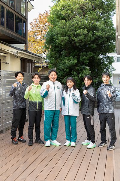 町田寮のテラスにて、原監督夫妻と4年生の男子マネージャー陣。左から、阿戸将太朗さん、白石さん、原監督、美穂さん、德澄主務、松下勇樹さん。阿戸さんは皆渡選手と同じ近畿地区出身で入学前から一緒に練習する間柄だったといい、「僕が選手を引退するかマネージャーになるかの瀬戸際で悩んでいたとき、寄り添ってくれた」と教えてくれた。松下さんといえばXのnote。これぞ青春、と思わせてくれる熱い思いが溢れている。