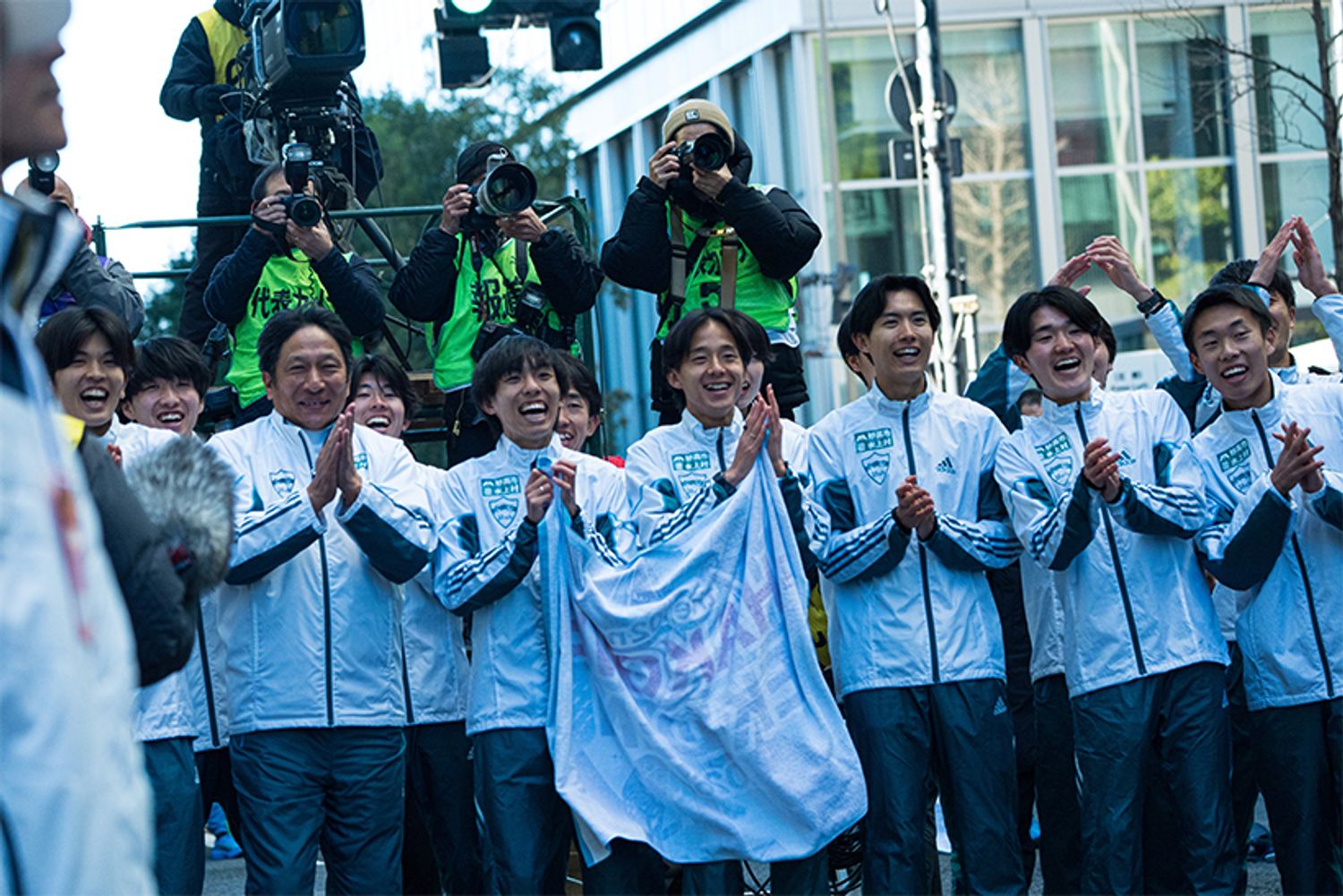 1月3日、大手町。「壮太」コールと手拍子で、アンカーの折田壮太選手（2年・10区）を待ち受ける青山学院大学の皆さん。前列左から、佐藤有一選手（4年・9区）、原 晋監督、黒田朝日主将（4年・5区）、塩出翔太選手（4年・8区）、佐藤愛斗選手（2年・7区）、石川浩輝選手（1年・6区）、荒巻朋熙選手（4年）。