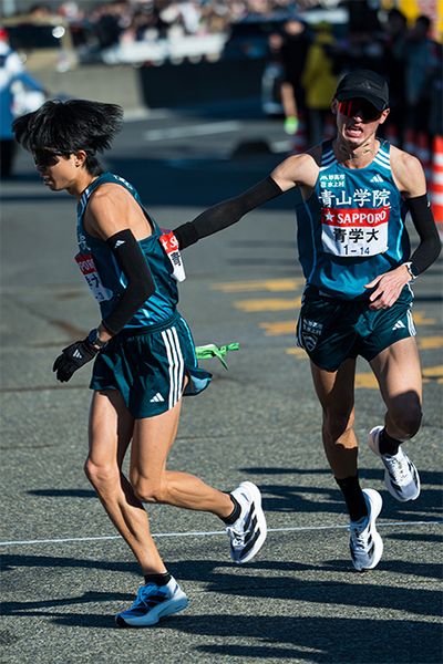 2区飯田翔大選手（右・2年）から、3区宇田川瞬矢選手（左・4年）への襷渡し。飯田選手は箱根駅伝初出走ながらエース区間を冷静に走り、チームの順位を16位から11位に押し上げた。チームきってのスピードランナーで、3年連続で箱根駅伝に出場した宇田川選手は、「レース中、運営管理車と並んで監督の顔が見えたとき、1mmも笑ってなくてやばいと思った」そう。「4年生の走りができなかった」と反省していたが、それでも順位を8位に上げた。