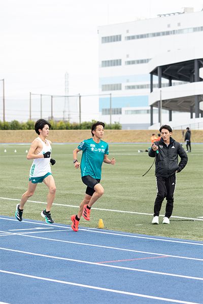 タイムを計っているのは德澄遼仁主務（4年）。高校時代に病気で競技を断念してマネージャーに転身した德澄主務は、青山学院大学の陸上部には珍しく、1年時から4年間マネージャーとしてチームをサポート。優勝直後の感想は「みんなが頑張ってくれて、感無量ですね」。泣きました？と聞くと、「運営管理車でこっそり。飯田、平松が上がっていったときに泣きました。ゴールでは喜びのほうが勝って、『ヨッシャー！』って。泣けませんでした」と楽しそうに話してくれた。