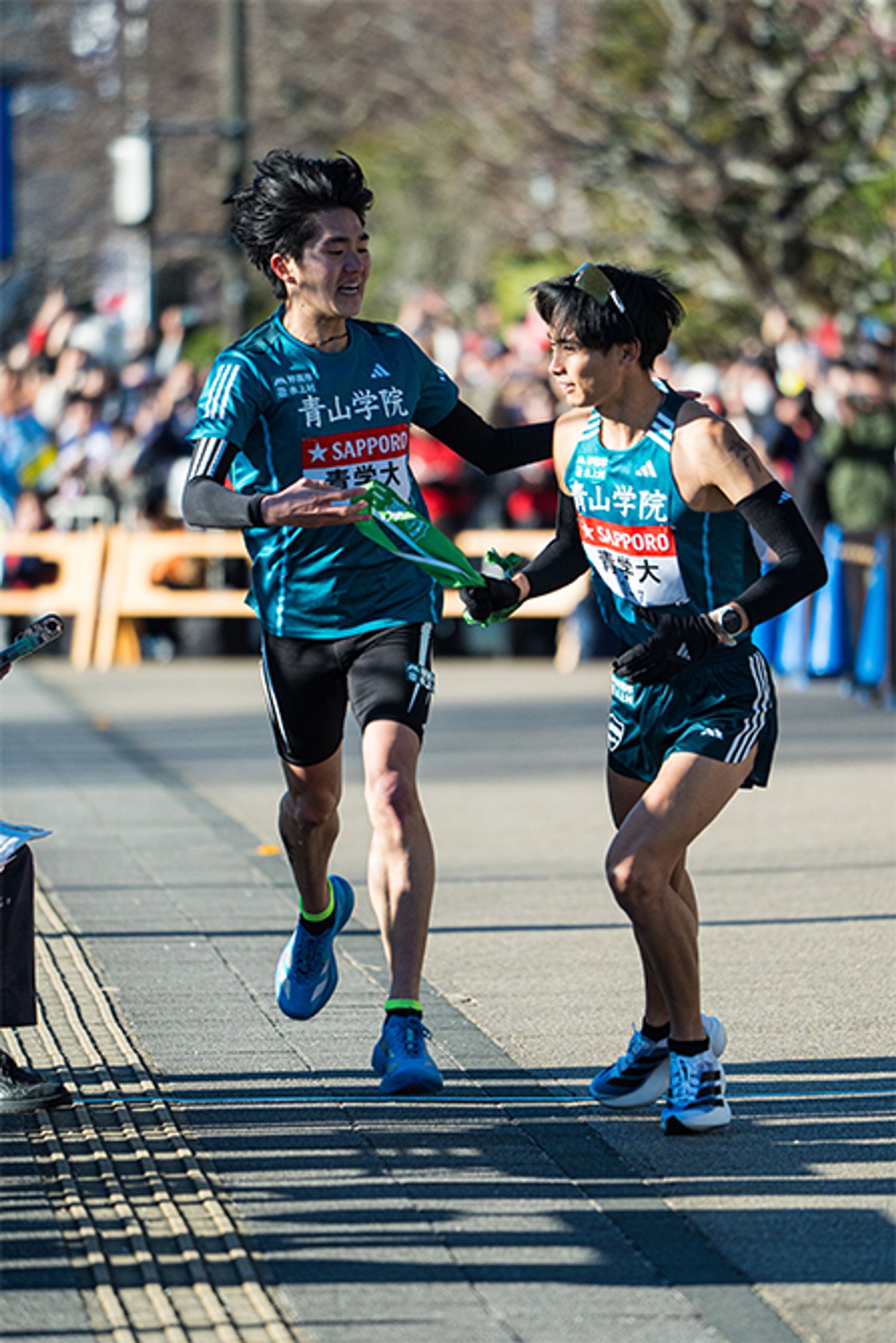 1月3日小田原中継所、復路6区の石川浩輝選手（1年）から7区の佐藤愛斗選手（2年）への襷リレー。石川選手は、山下りの6区でルーキーらしからぬ堂々とした走りを見せ、区間3位に。6区の１年生記録を更新した。レース後、石川選手がテレビカメラの前で見せた無邪気な笑顔とノーダメージに見えるきれいな足の裏に、この先3年間、6区は青山学院大学のストロングポイントになると確信した。