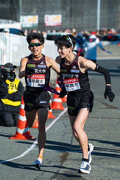 2区上原主将（左・4年）から、3区野中恒亨選手（右・3年）へ襷が渡る。上原主将は各大学の実力者が揃ったエース区間を区間12位で走り、チームの順位は1位から6位へ。頼れるエースの1人、野中選手は区間3位のタイムで順位を1つ上げ、5位で辻原 輝選手（3年）に襷を繋いだ。