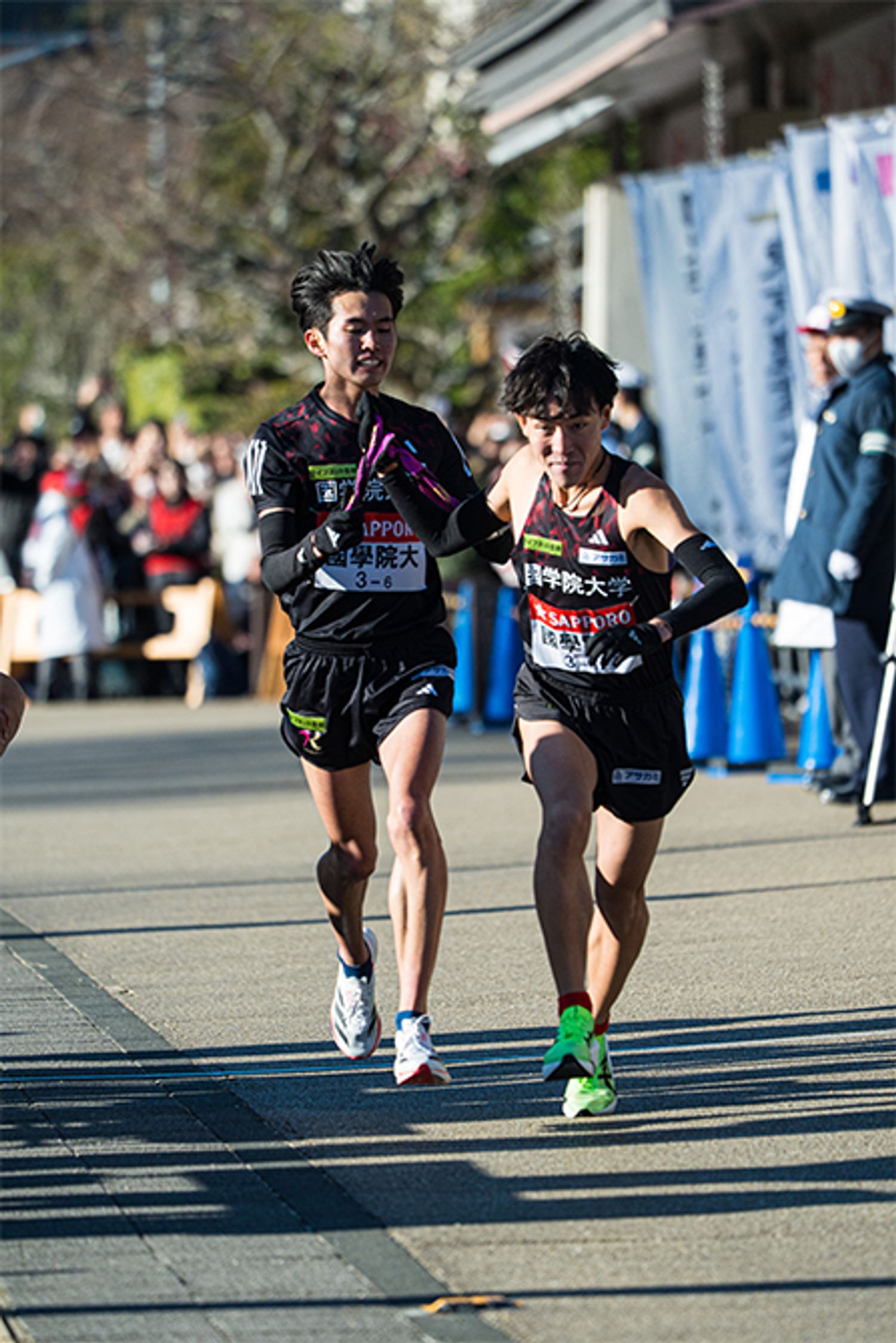 1月3日の復路、6区の後村光星選手（左・3年）から7区の高山豪起選手（4年）への襷リレー。大会前、前田監督は、「高山は力のある選手なんですが、箱根に嫌われていて、3回走って、全部区間2桁（順位）なんです。彼が本来の力を出せれば、優勝に近づけると思います」と話していたが、今回は7区区間賞を獲得し、國學院記録も更新。チーム順位も２つ上げて2位に。これまでの悔しさを完全に払拭した。