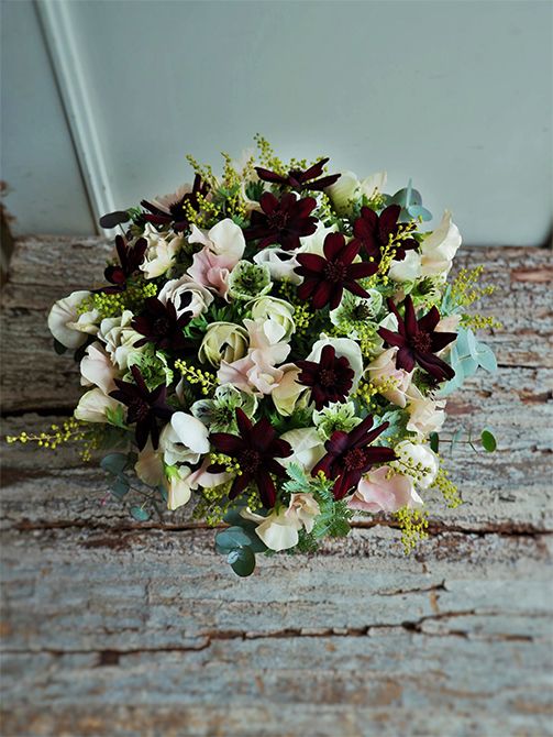 バレンタインデーがお誕生日の恩師へ、教え子さんからお祝いの贈り花です。アネモネ‘ミストラル ホワイトセンターブラック’、ニゲラ‘アフリカンブライド’、スイートピー‘めぐみ’とごく淡い花色を集め、チョコレートコスモスの濃い花色でぐっと引き締めてみました。アレンジ全体にギンヨウアカシアをあしらって、ナチュラルな雰囲気に仕上げています。