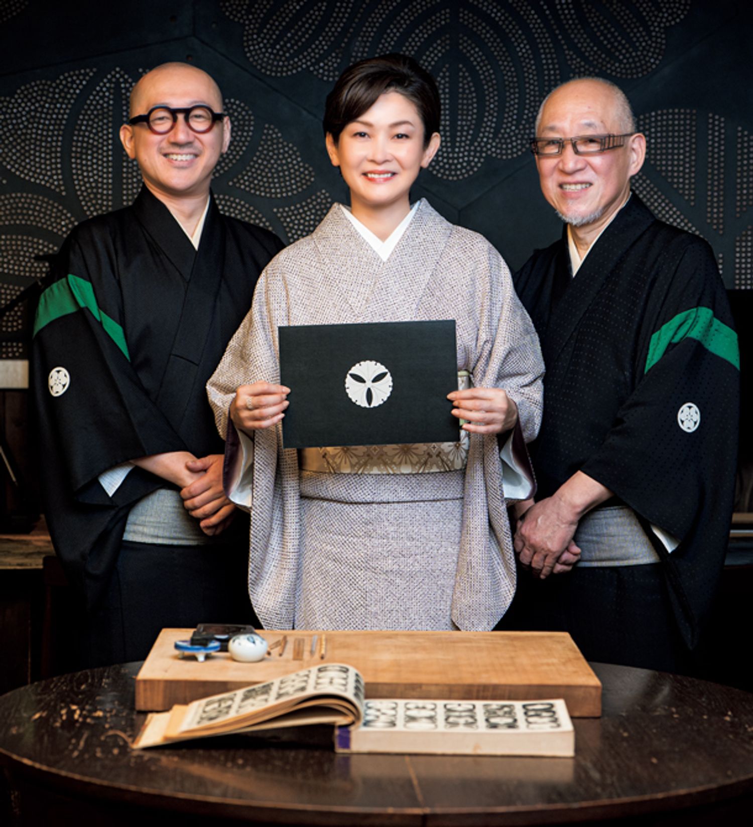 完成した三ツ銀杏の上絵の作品とともに、波戸場承龍さん（右）と耀鳳さん（左）との記念のワンショット。一見すると無地のような承龍さんのきものの地紋は霰柄、耀鳳さんは鱗柄。ここにも“円と線”の美学が秘められています。