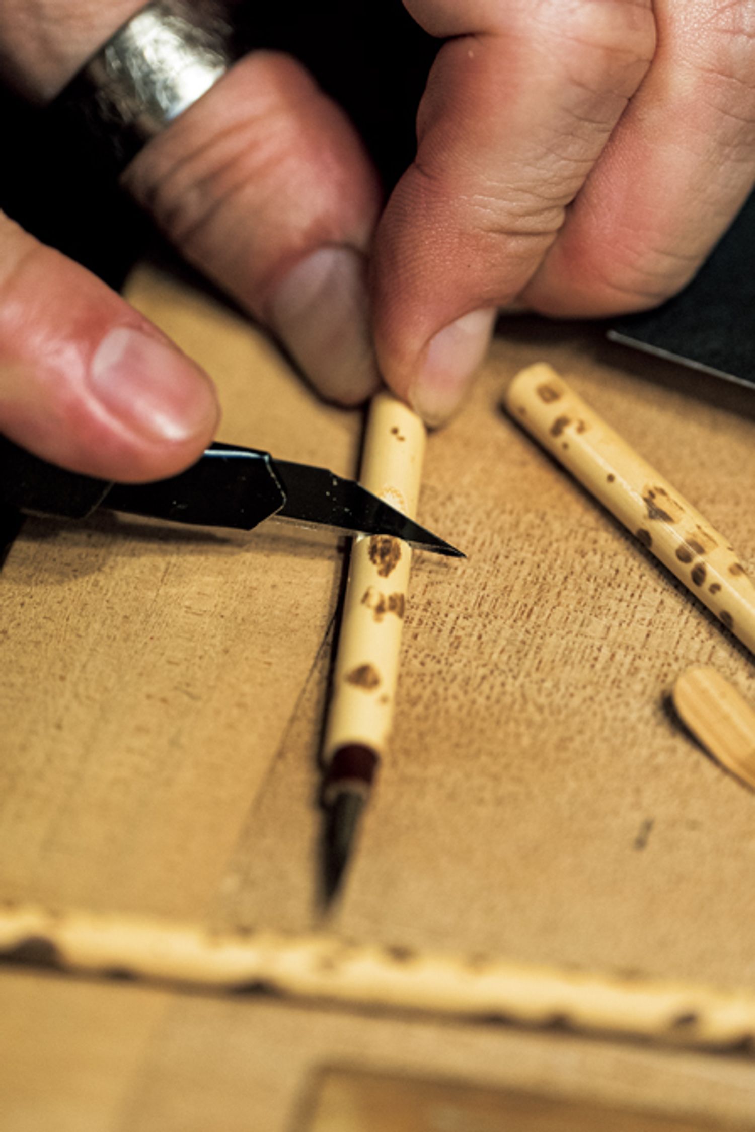 筆を使いやすい長さにカットする様子に、「道具を扱う指先にも、熟練の職人の息遣いが感じられますね」と藤間さん。