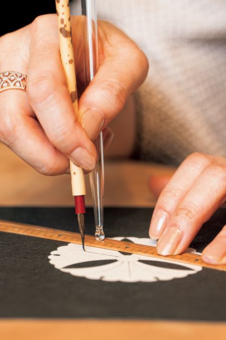 今回は、手漉きの越前和紙に通常の男紋の倍となる2寸の三ツ銀杏を描く。「墨のつけ方もうまいですね」と承龍さんにお褒めの言葉をいただくと、「師匠の仕事を間近で見ておりましたので」と藤間さん。季節によって墨の乾き方が異なるため熟練の技術と経験を要する。