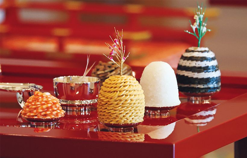 古式に則った宮中料理が並ぶ。右手前から紅梅を立てた「雲丹篠蒲鉾（うにしのかまぼこ）」、高盛御飯、「塩引干鰤（しおびきほしぶり）」には白梅が立つ。左は「塩茹才巻海老（しおゆでさいまきえび）」。