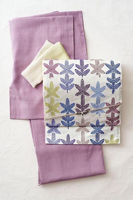 格調の高い若松文様も、現代的な色調の名古屋帯なら紬に合わせて軽やかな装いに。