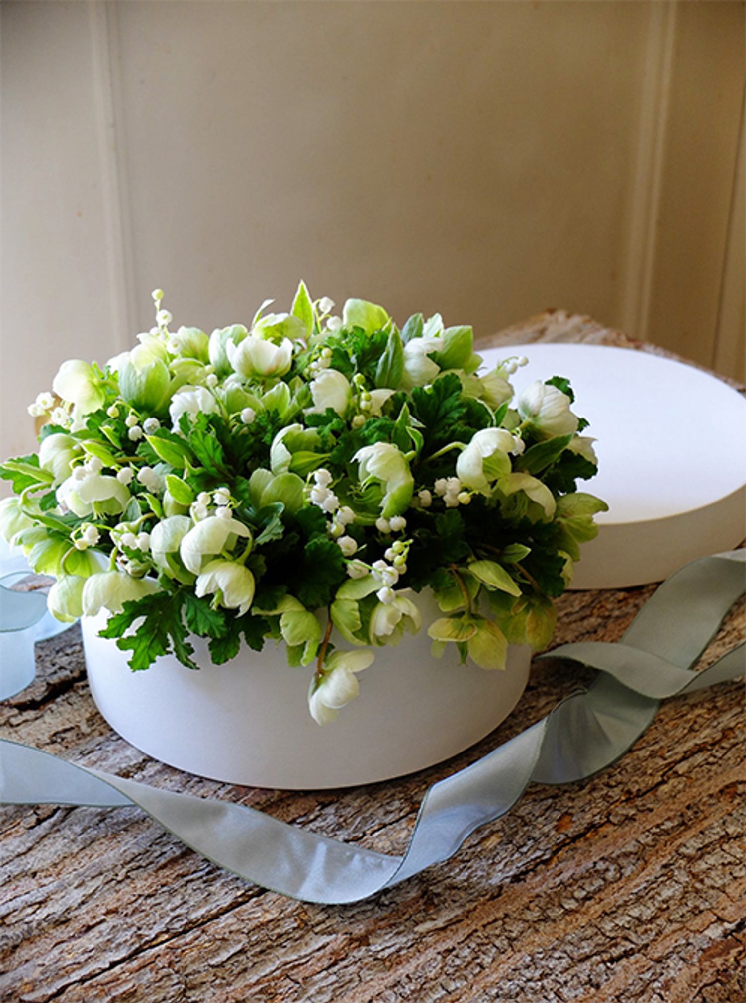 スズランを使った花箱をもう1種。クリスマスローズの‘マグニフィセントベルズ’のみのシンプルな花合わせで、ナチュラルで清楚な印象に仕上げました。ふたを開けるとスズランの清潔感あるさわやかな香りがふわっと感じられます。直径20cmのボックスを使用。