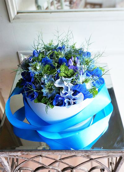 結婚式でお世話になっているプランナーさんに感謝の気持ちを込めた贈り花です。プランナーさんの好きなブルーの花を集めました。スイートピー‘アッシュブルー’、ニゲラ‘ミスジーキル’、デルフィニウム‘ブルーオリオン’にスペアミントを添え、スイートピー‘ブルーフレグランス’の巻きつるで動きを加えました。直径20cmのボックスを使用。