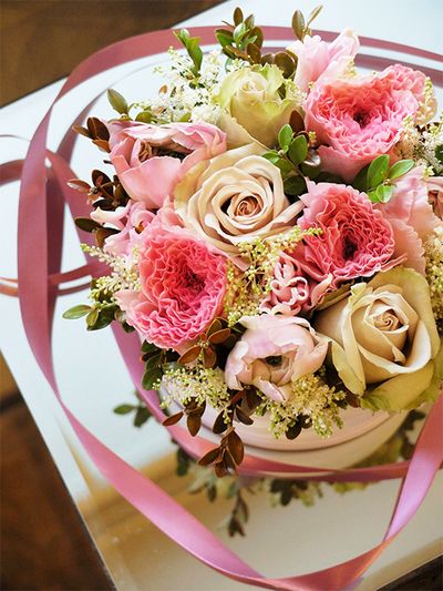 ピンク×淡いベージュの組み合わせを花箱にすると、どこかアンティークな雰囲気に。バラ、ラナンキュラス、チューリップ、と大きめの花を利用しましたが、すき間をアスチルベ‘ダイヤモンド’がきれいに埋めてくれます。バラは‘デザート’、ラナンキュラスは‘ちほの恋’、チューリップは‘ダイナスティーピクチャー’をセレクト。あしらいに紅ツゲを加えました。直径15cmのボックスを使用。