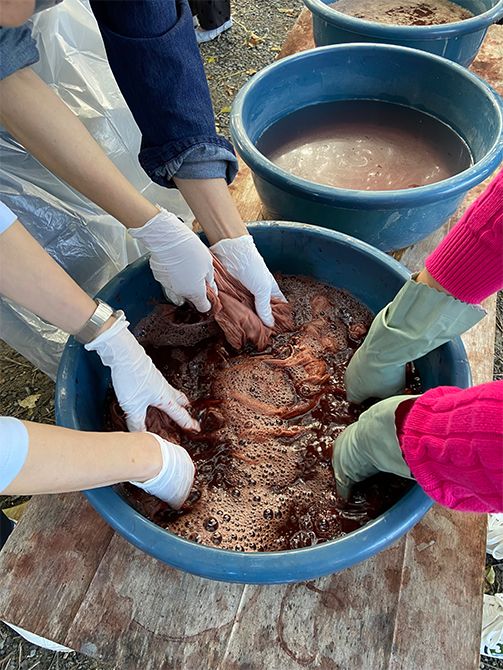 本来、大島紬は締め機で織ることで防染しますが、今回は手で糸をくくり、仕上がりの柄をイメージしながら防染します。テーチギの薄紅色と、泥の灰色を染め分けながら、好みの濃さになるまで何度も染め重ねていきます。