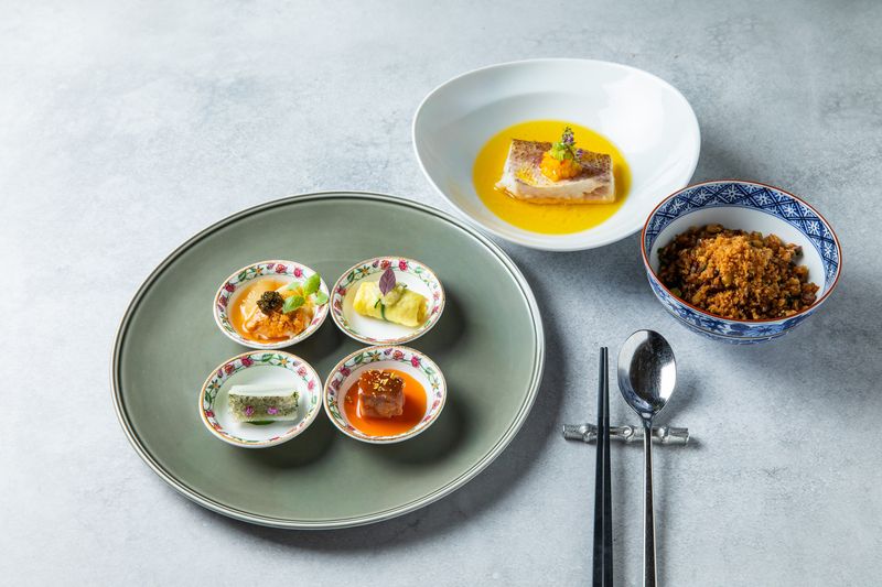 ランチコース「秦始皇」内でいただけるジミーシェフの料理3品。前菜のほか、スジアラにピリ辛ソースを合わせた「スジアラの鶏油蒸し」、燻製した筍と生の筍に、ほろ苦いからし菜を合わせ中華醤油で香ばしく炒めた「干し豚肉と干し筍の中華醤油炒飯」。 