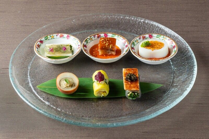 「前菜盛り合わせ」／写真左上より時計まわりに、金華ハム からし菜の筍包み、もち米入り蓮根のザクロシロップ風味、ウニ入りイカのニンニクスパイシーソース、キャビアのせ野菜巻き、蒸し鶏のせクラゲの和え物、フォアグラの老酒風味。 