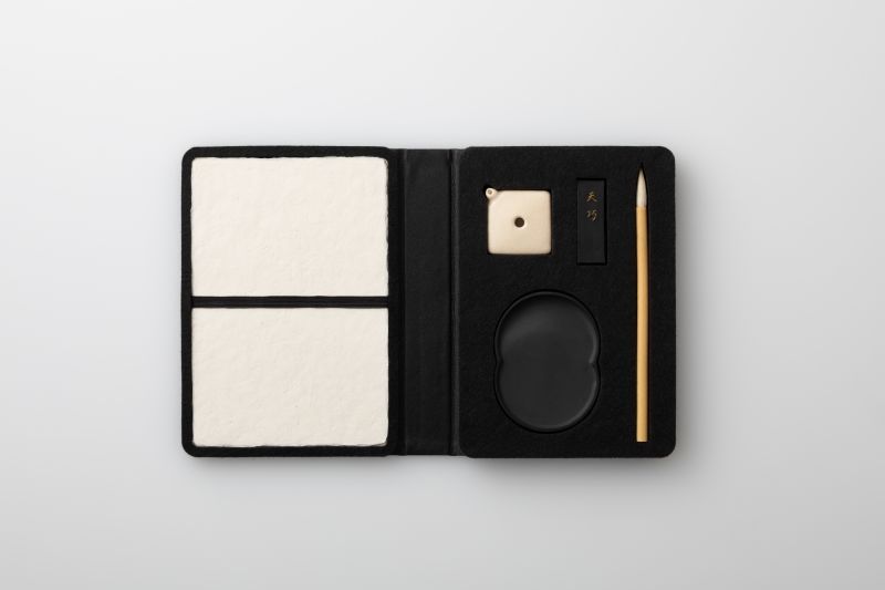 「甲斐雨端硯 硯一式 携帯型（予定価格5万5000円）」（縦X×開いたときの幅X×厚さXセンチメートル）。こちらは日月硯のタイプのみ。和紙は上下に分かれている。