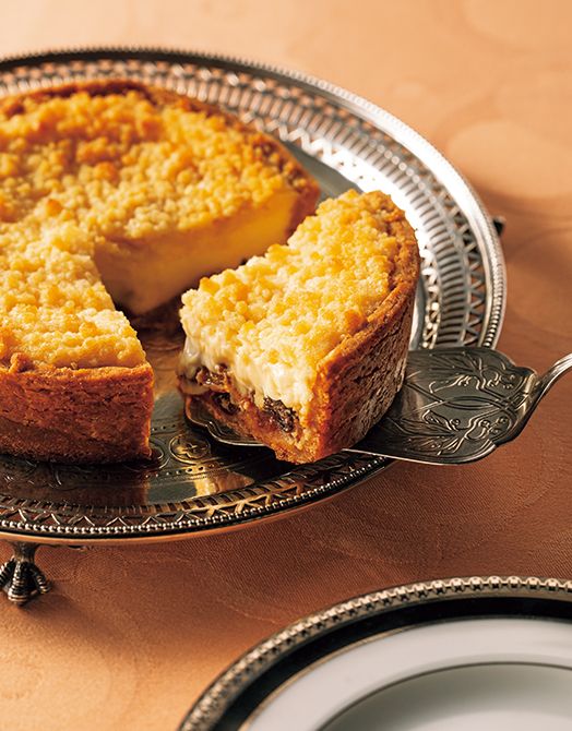 口溶けのよいチーズのフィリングにサクサクのカソナードクランブルを重ね、タルト生地にもパルメザンチーズを練り込んでリッチな仕上がりに。ラム酒に漬け込んだレーズンたっぷりのミックスフルーツが香りと甘みのアクセントに。